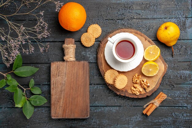 Top view cup of tea with fruits and cookies, sweet biscuits sugar