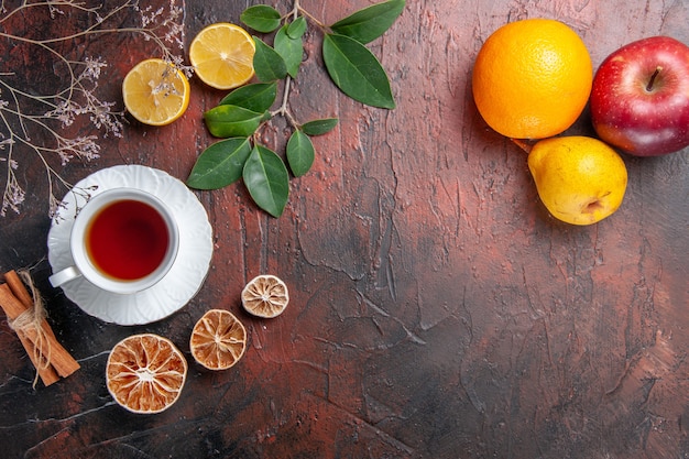 Top view cup of tea with fruits on dark table sugar tea photo biscuit sweet