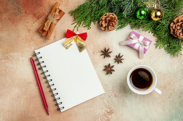 Top view cup of tea with green branch and presents