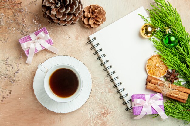 Top view cup of tea with green branch and presents