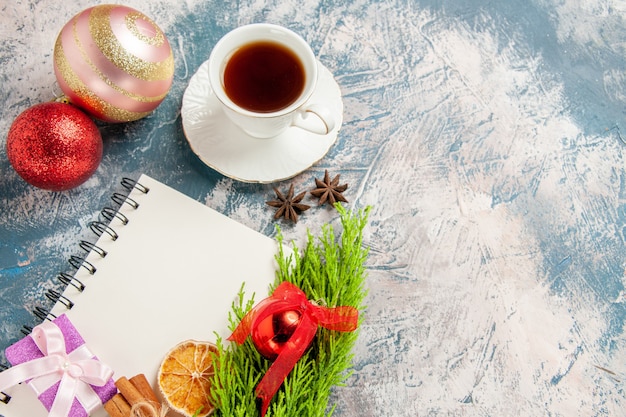 Free photo top view cup of tea with green branch and toys