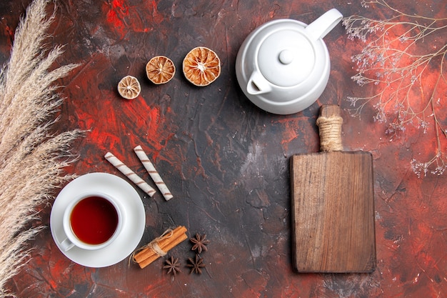 Top view cup of tea with kettle on dark table