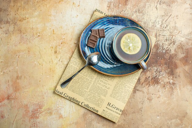 Top view cup of tea with lemon on brown background