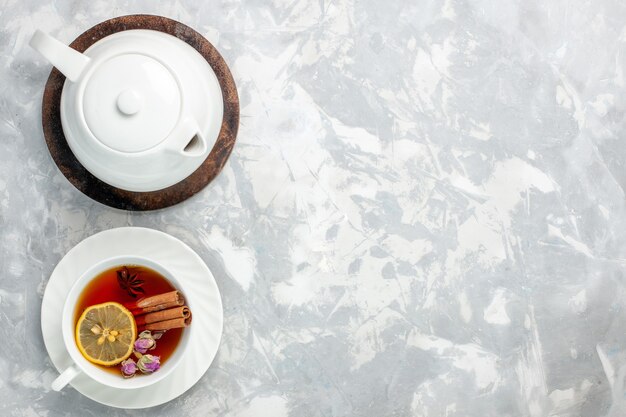 Top view cup of tea with lemon and cinnamon on the light white surface