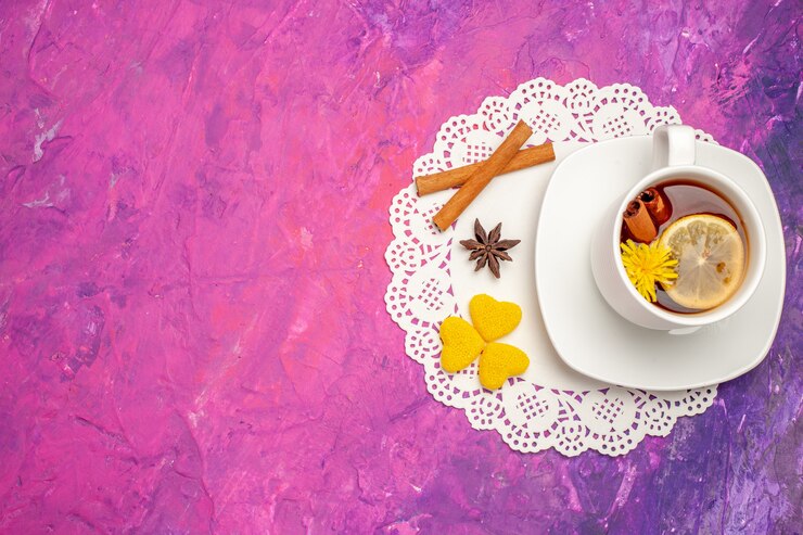 मुफ़्त फोटो top view cup of tea with lemon and cinnamon on a pink table tea color candy