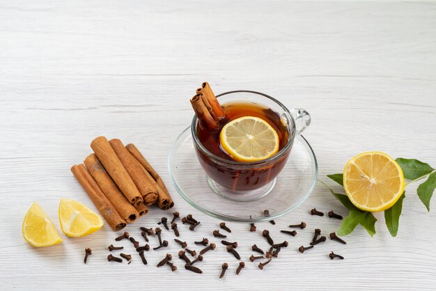 A top view cup of tea with lemon and cinnamon on white, tea dessert candy