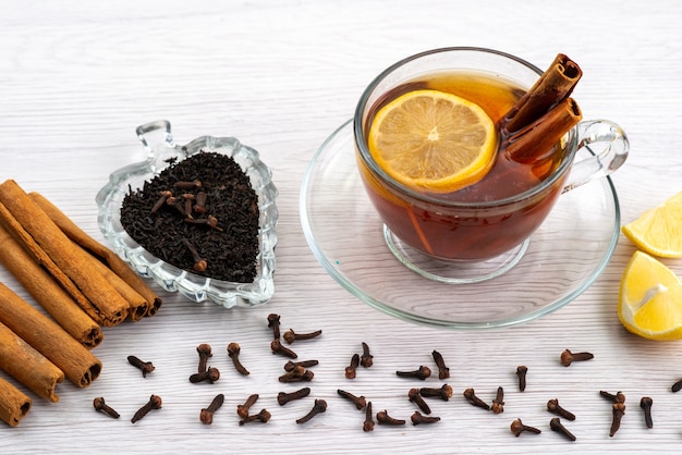 A top view cup of tea with lemon and cinnamon on white, tea dessert candy