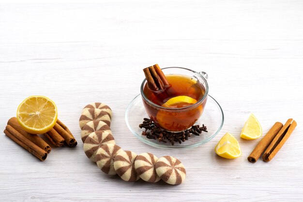 A top view cup of tea with lemon and cinnamon on white, tea dessert candy