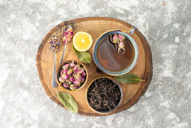 Top view cup of tea with lemon and flowers on light background breakfast ceremony flavor fruit color morning flower