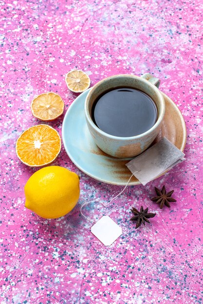 Free photo top view cup of tea with lemon on pink background.