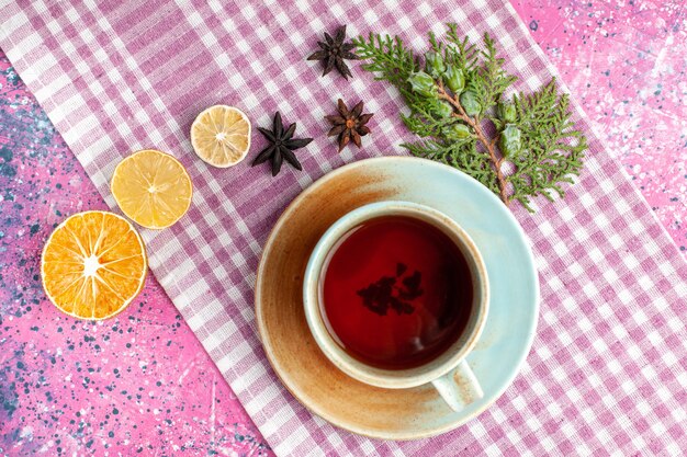 Top view cup of tea with lemon on pink desk