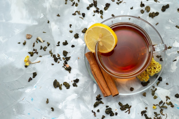 A top view cup of tea with lemon slice and cinnamon on bright, drink liquid fruit