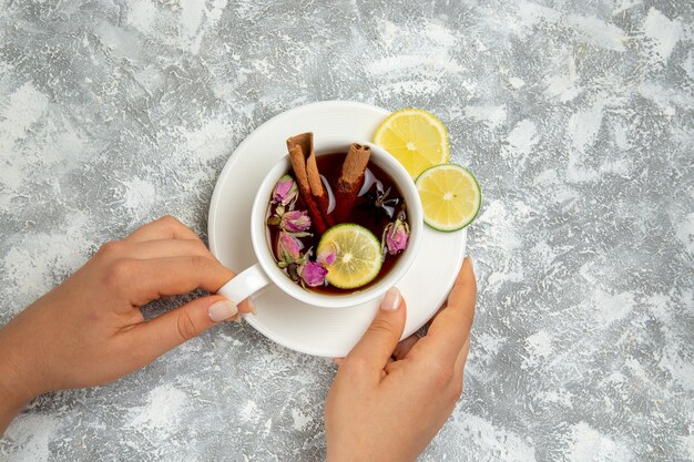 Top view cup of tea with lemon slices and cinnamon on the white background tea drink hot sweet sugar breakfast