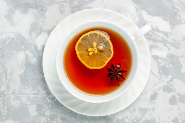 Top view cup of tea with lemon on white surface