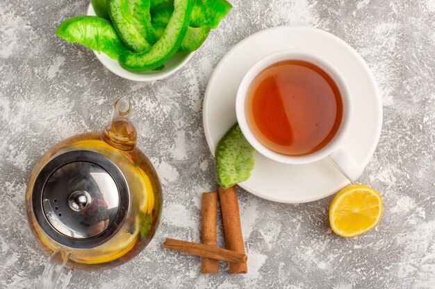 Top view cup of tea with lemons and cinnamon on light-white surface