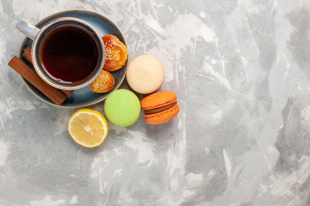 Top view cup of tea with macarons on white surface
