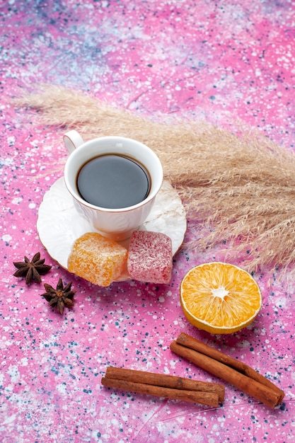 Top view cup of tea with marmalade and cinnamon on pink background