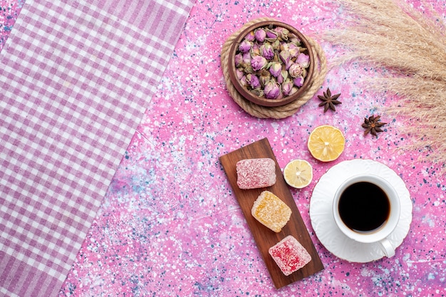 Vista dall'alto tazza di tè con pezzi di marmellata sulla scrivania rosa.