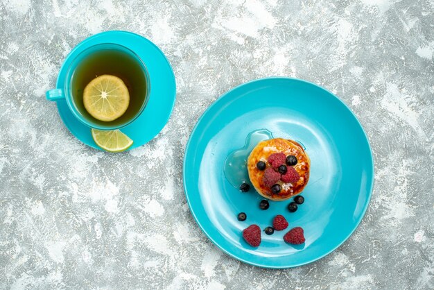 Top view cup of tea with muffins on light background