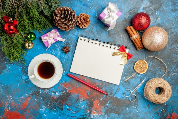 Free photo top view cup of tea with notepad and toys