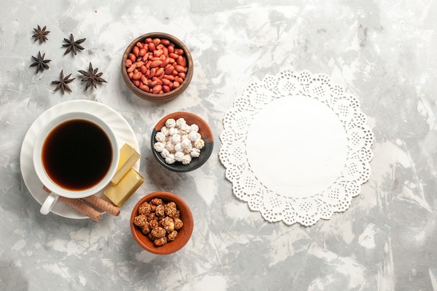 Top view cup of tea with nuts and cookies on white surface