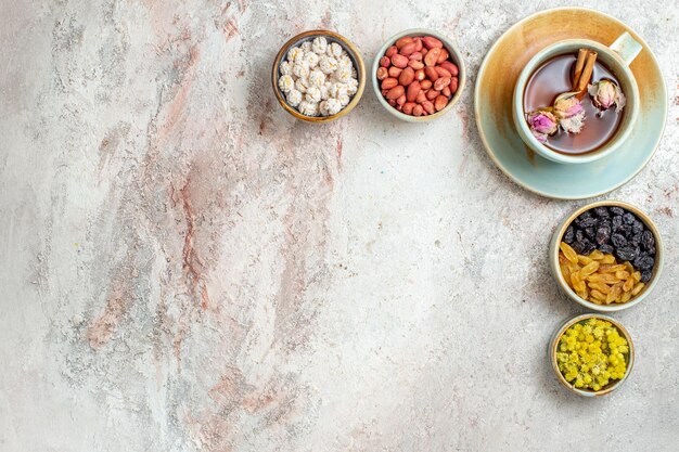 Top view cup of tea with raisins and nuts on white surface tea nut raisin ceremony