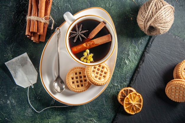 top view cup of tea with sweet biscuits on dark background