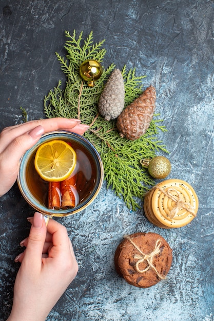 Top view cup of tea with sweet biscuits on light-dark background