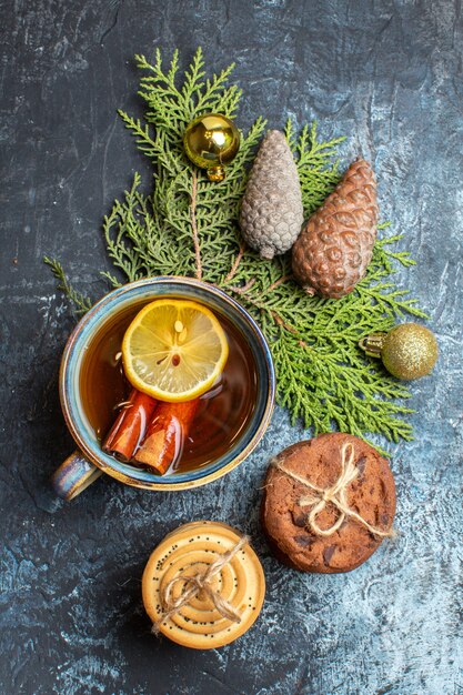 Top view cup of tea with sweet biscuits on light-dark background