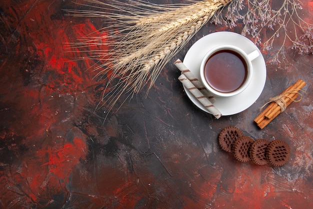 Vista dall'alto tazza di tè con biscotti dolci sul tavolo scuro