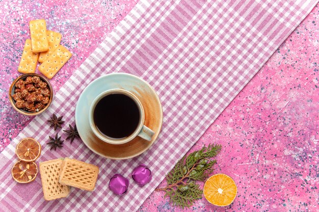 Top view cup of tea with waffles and crackers on pink