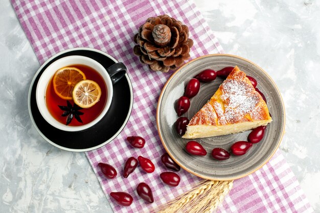 Top view cup of tea with yummy cake slice on white wall biscuit sugar cake sweet pie