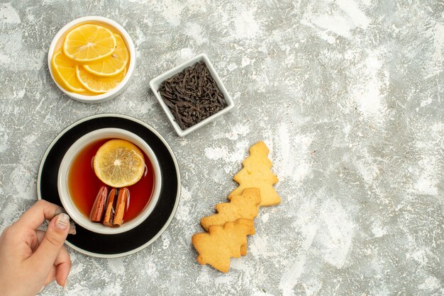 Вид сверху чашка чая в миске для печенья с шоколадом и дольками лимона на серой поверхности свободного пространства