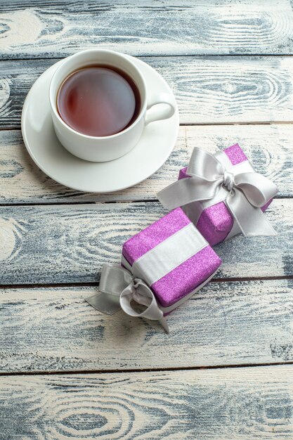 Top view a cup of tea xmas gifts on wooden background