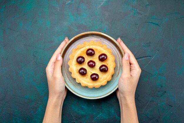 Free photo top view of cupcake with cherries which someone serves