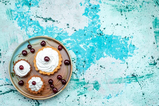 Top view of cupcake with creamy surface and cherries