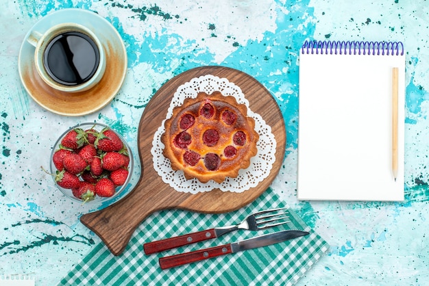 Top view of cupcake with fried surface next to notebook and americano