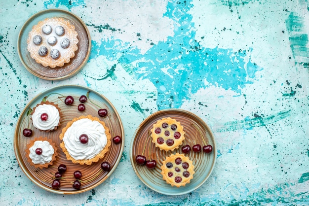 Free photo top view of cupcakes with cherries and all different styles