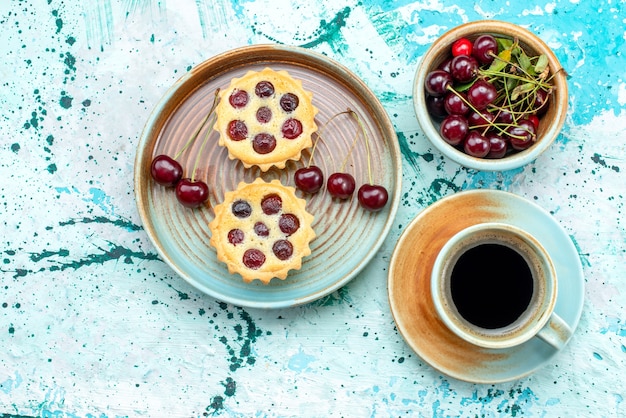 Vista dall'alto di cupcakes con ciliegie fresche e decorazione del sole