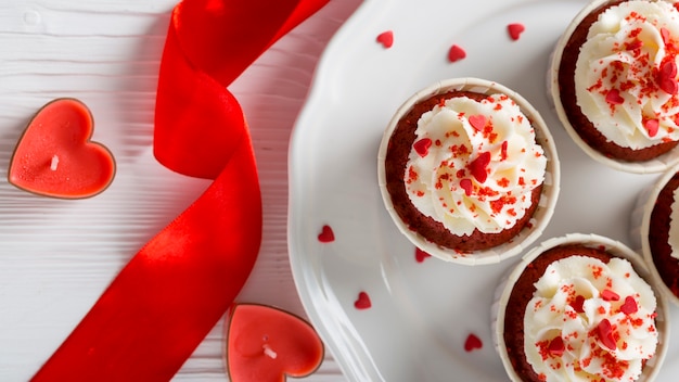 Foto gratuita vista dall'alto di cupcakes con candele a forma di cuore e nastro