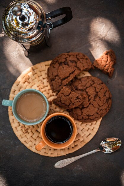 Top view cups of coffee with cookies