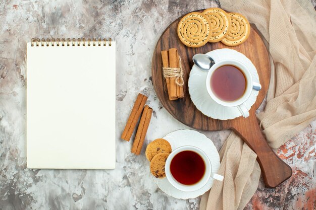 Top view cups of tea with sweet biscuits and cookies on light background break sugar cake pie color coffee