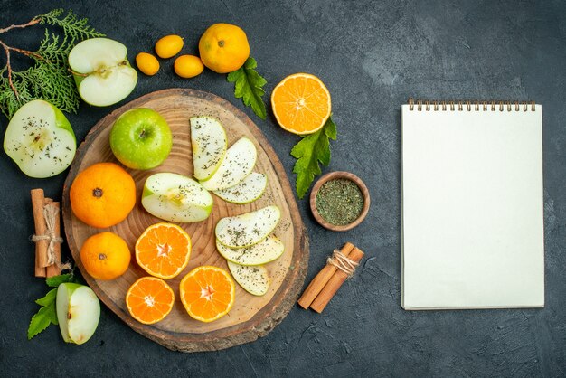 Top view cut apples and mandarines on rustic serving board