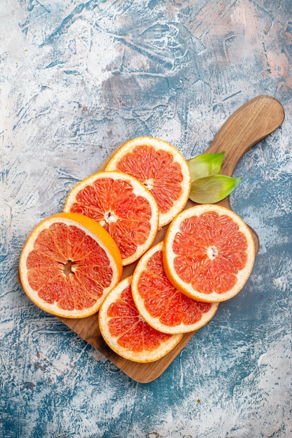 Top view cut grapefruits on cutting board on blue white surface