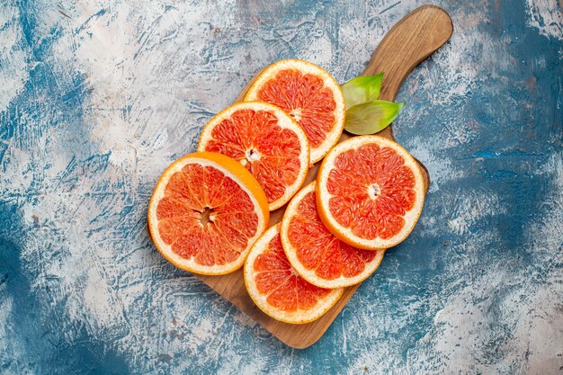 Top view cut grapefruits on cutting board on blue white surface