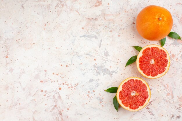 Top view cut grapefruits fresh grapefruit on nude surface with free space