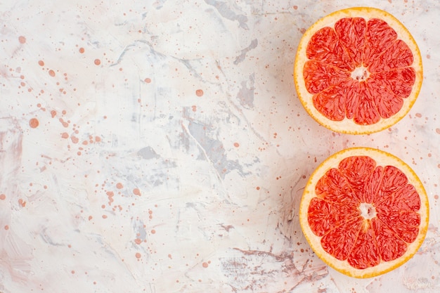 Free photo top view cut grapefruits on nude surface free space