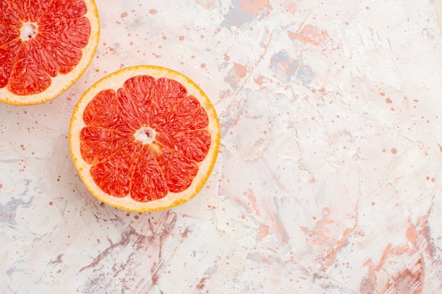 Top view cut grapefruits on nude surface with copy space