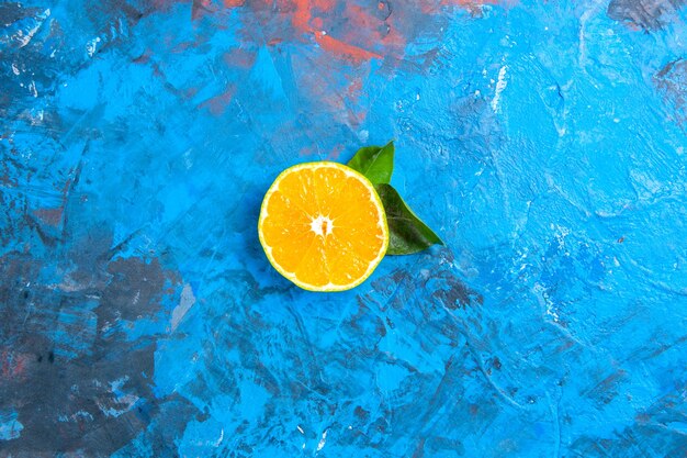 Top view cut orange on blue surface with free space