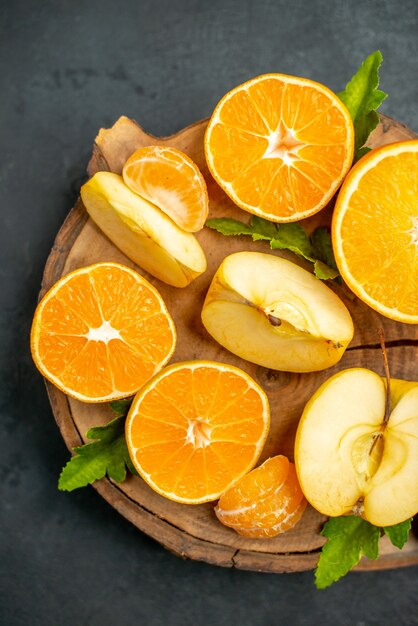 Вид сверху нарезанные апельсины и яблоки нарезанные апельсином на темном фоне